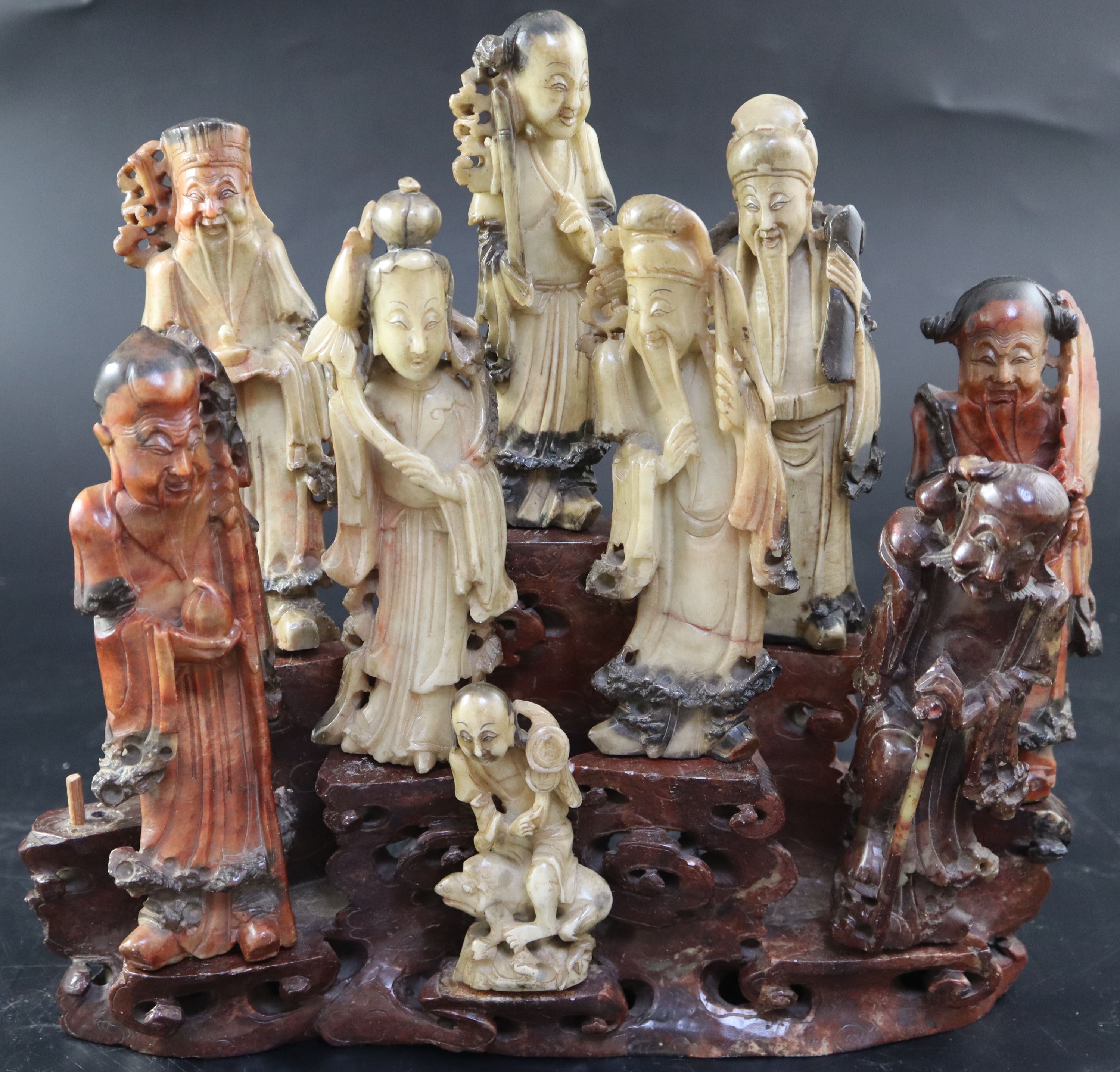 A group of nine Chinese Taoist carved coloured soapstone figures of immortals, width 29cm height 27cm